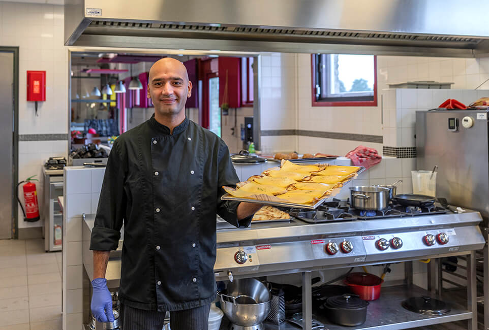 Portret cliënt aan het werk in de keuken i.o.v. Sherpa zorg